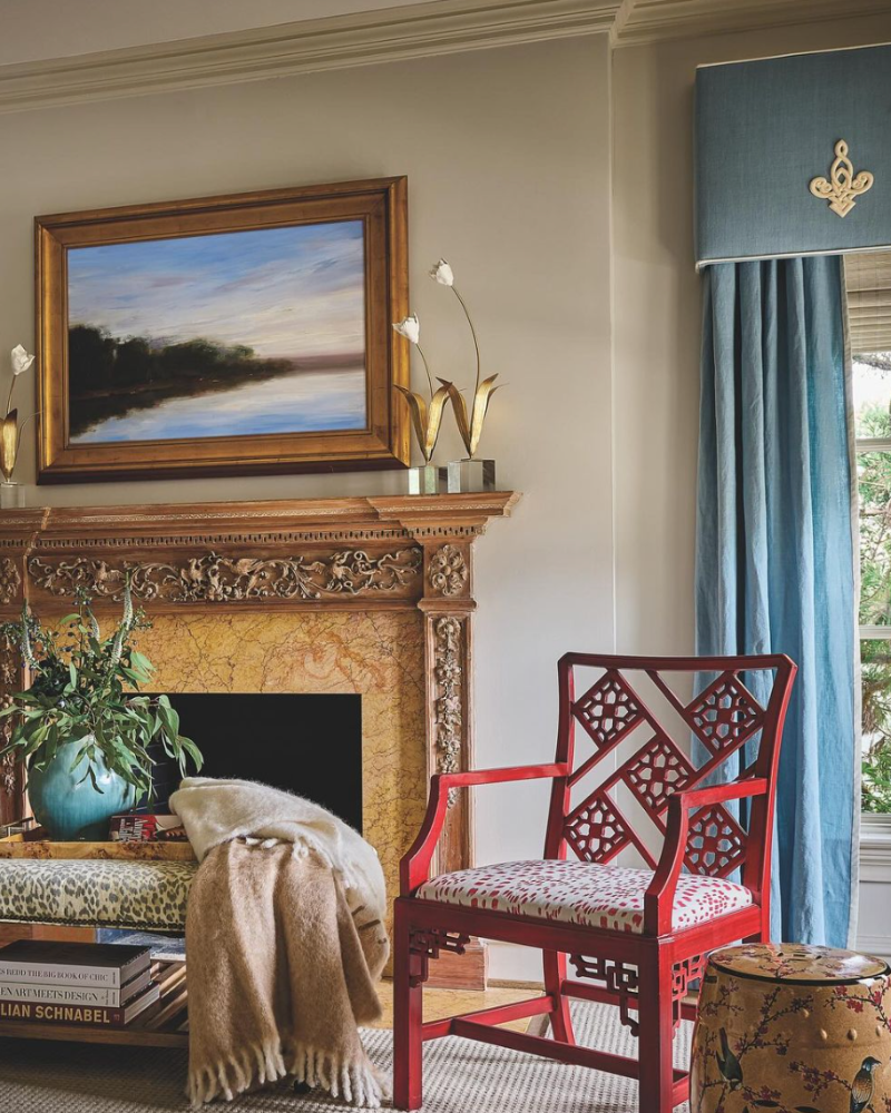traditional room with fireplace, red chair, and blue curtains