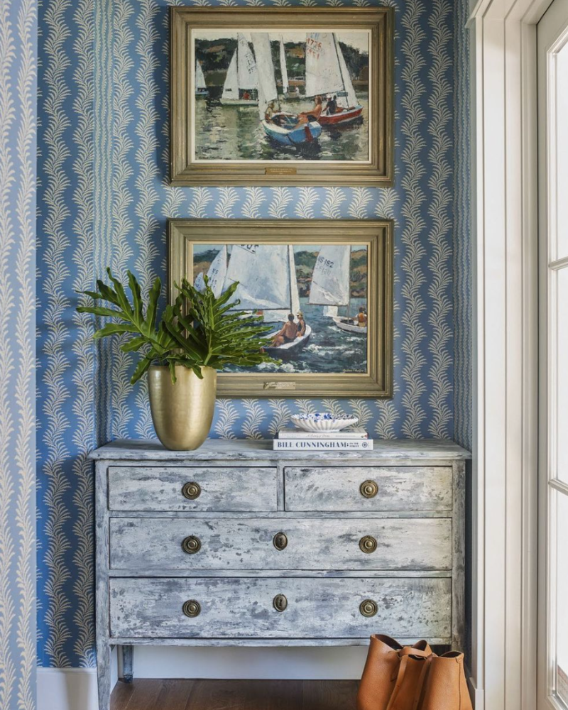 blue wallpaper, sailboat paintings and antique chest